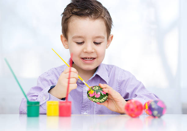 istock Cute boy with basket full of colorful eggs 467023914