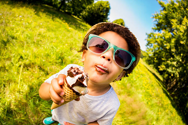 glückliche junge lecken genießen sie ein eis an einem heißen sommertag - child chocolate ice cream human mouth stock-fotos und bilder