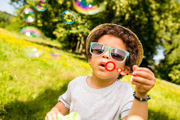 istock Brazilian boy busy blowing bubbles in nature 467030513