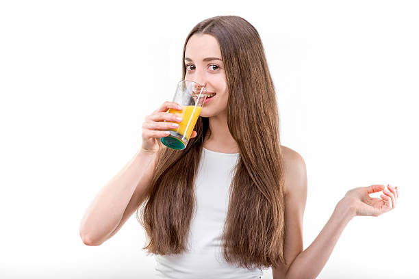 istock Girl dressed in a white shirt drinking orange juice 467035589