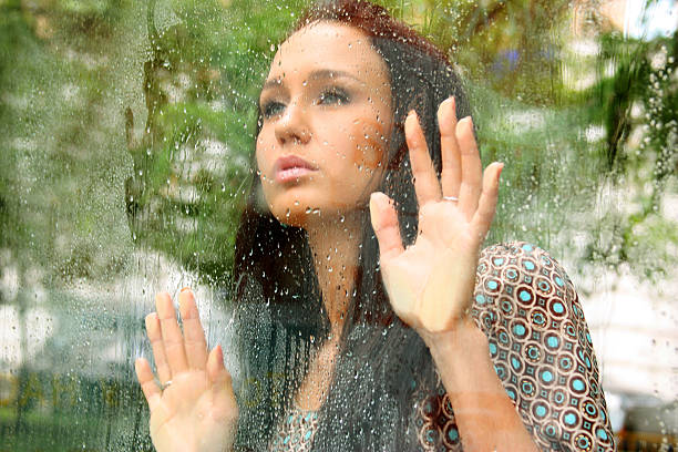 istock woman near window after the rain 467038599
