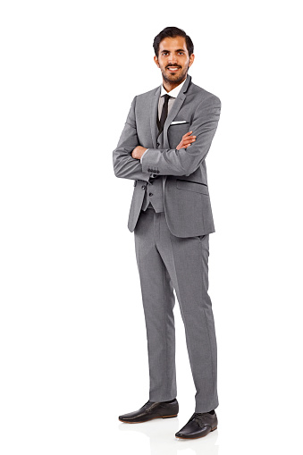 Full length portrait of successful young businessman standing with his arms crossed over white background