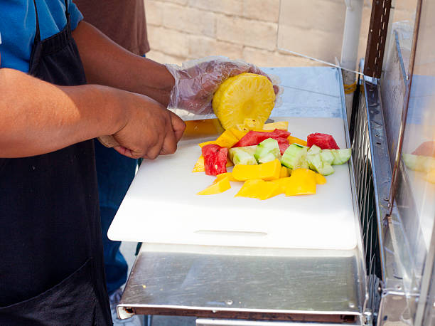 Fruit vendor Cutting fruits and vegetables. fruit cart vendor stock pictures, royalty-free photos & images