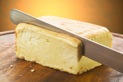 Taleggio cheese on cutting board sliced