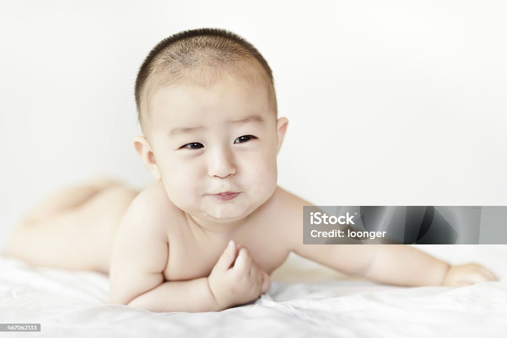 Naked gracioso Bebê Menino agachamento na cama branca - Foto de stock de 0-11 meses royalty-free