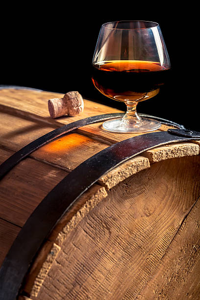 Glass of cognac on the vintage wooden barrel Glass of cognac on the vintage wooden barrel. cognac stock pictures, royalty-free photos & images