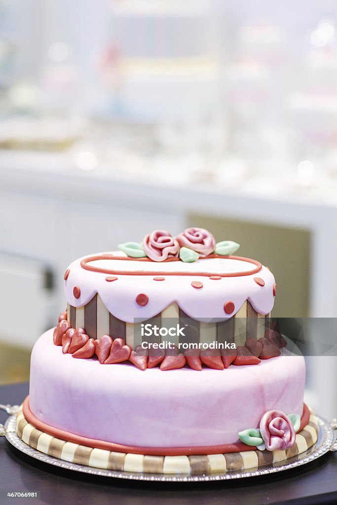 Wedding cake decorated with pink rose flowers and hearts . Wedding cake decorated with pink rose flowers and hearts Bakery Stock Photo
