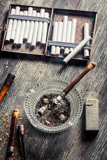 Smoked a pipe on the background of cigaretteCigarettes made from tobacco and tablets.