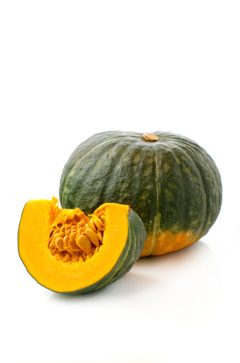 whole and sliced pumpkin on a white background