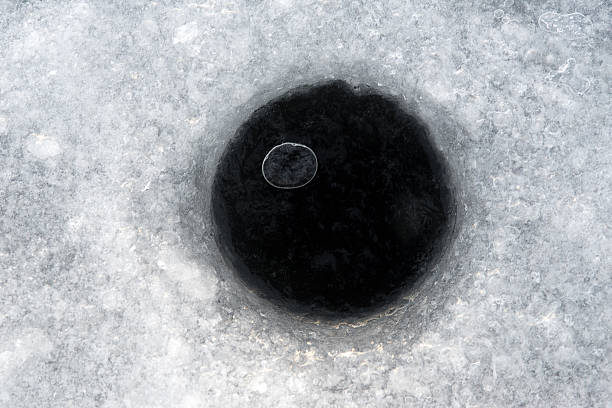 Black bowling ball in the white snow.