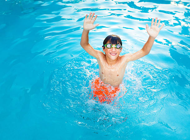 kid playing, jumping out of the water in a pool, vacations!