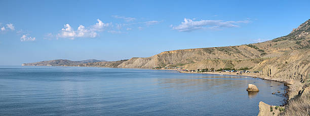 Panorama of Meganom peninsula and Lisya bay in Crimea Panorama of Meganom peninsula and Lisya bay (Fox bay) with tent camp under the Echki-dag mountains in summer morning, Crimea, Ukraine lisya bay stock pictures, royalty-free photos & images