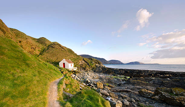 Path to White Cottage on a coast - Niarbyl Path to the White Fishermans Cottage on a coast - Niarbyl on the Isle of Man panoramic country road single lane road sky stock pictures, royalty-free photos & images