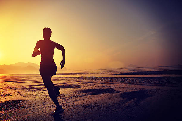 istock young woman running on sunrise beach 467084744