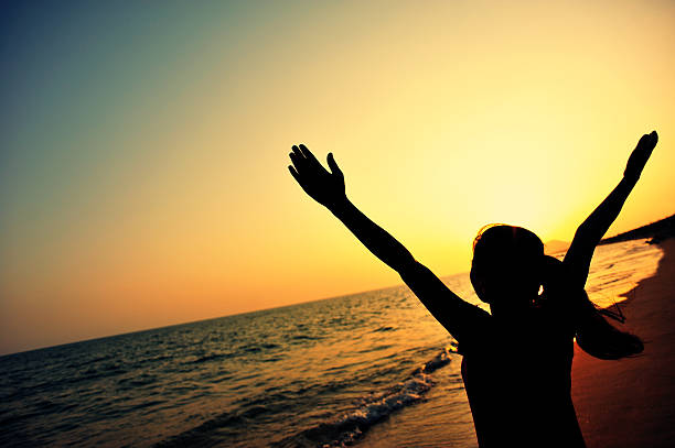istock cheering woman open arms at sunset  seaside 467084748