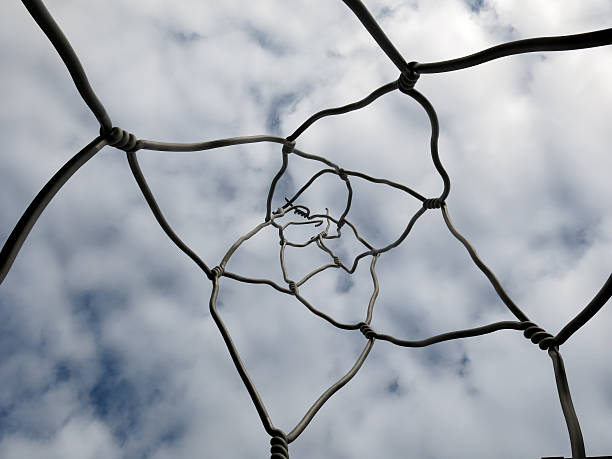 Wire fence in the clouds stock photo