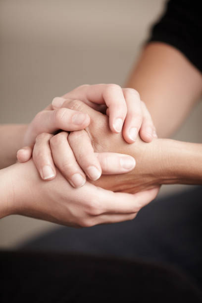 Cropped image of two hands holding someone else's hands