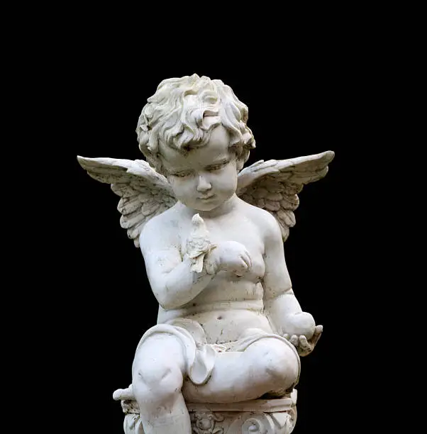 Photo of Stone cherub gazes down at bird (includes clipping path)