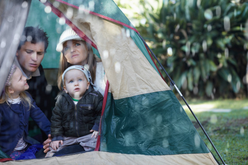 Young family stuck in their tent during a rainy day