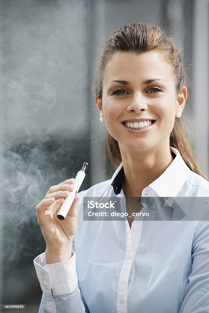 Портрет молодая женщина курить Электронная сигарета на открытом воздухе - Стоковые фото Электронная сигарета роялти-фри