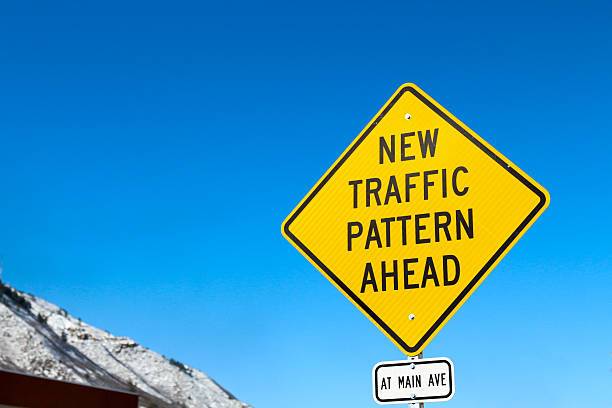 New traffic pattern ahead yellow diamond sign against blue sky