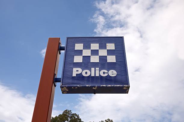 Brown sign post with blue and white police sign stock photo