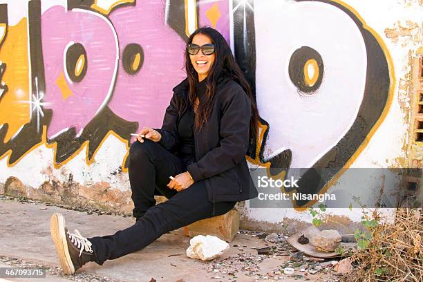 Photo libre de droit de Heureux Fumeur Femme Devant Un Mur De Graffiti banque d'images et plus d'images libres de droit de Adulte - Adulte, Assis, Beauté