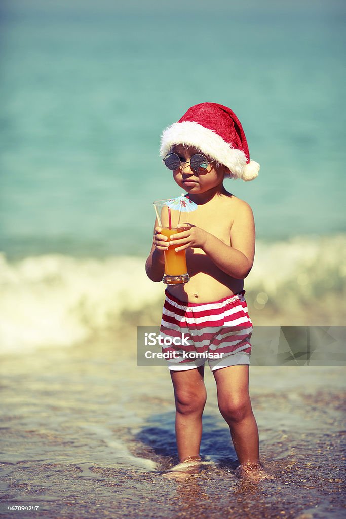 Piccolo Babbo Natale sulla spiaggia - Foto stock royalty-free di 12-17 mesi