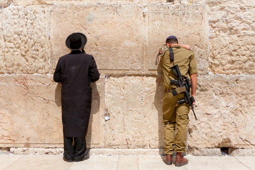 Jerusalem, Israel - July 18, 2010: Soldier and Orthodox jews pray at the wailing wall. Jerusalem with people.