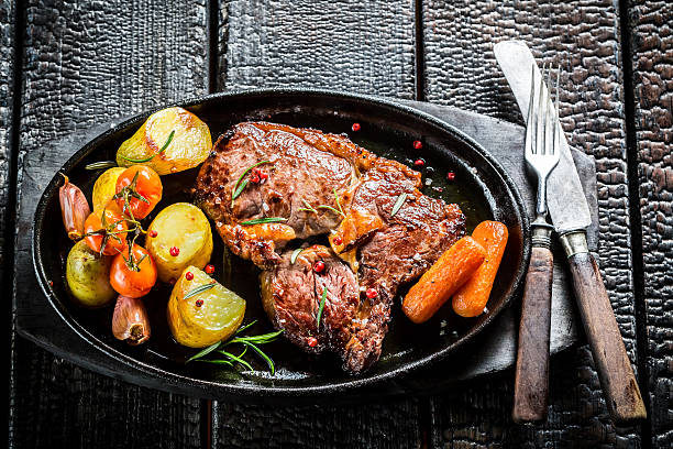 istock Roasted vegetables and steak with fresh herbs on grill 467097322