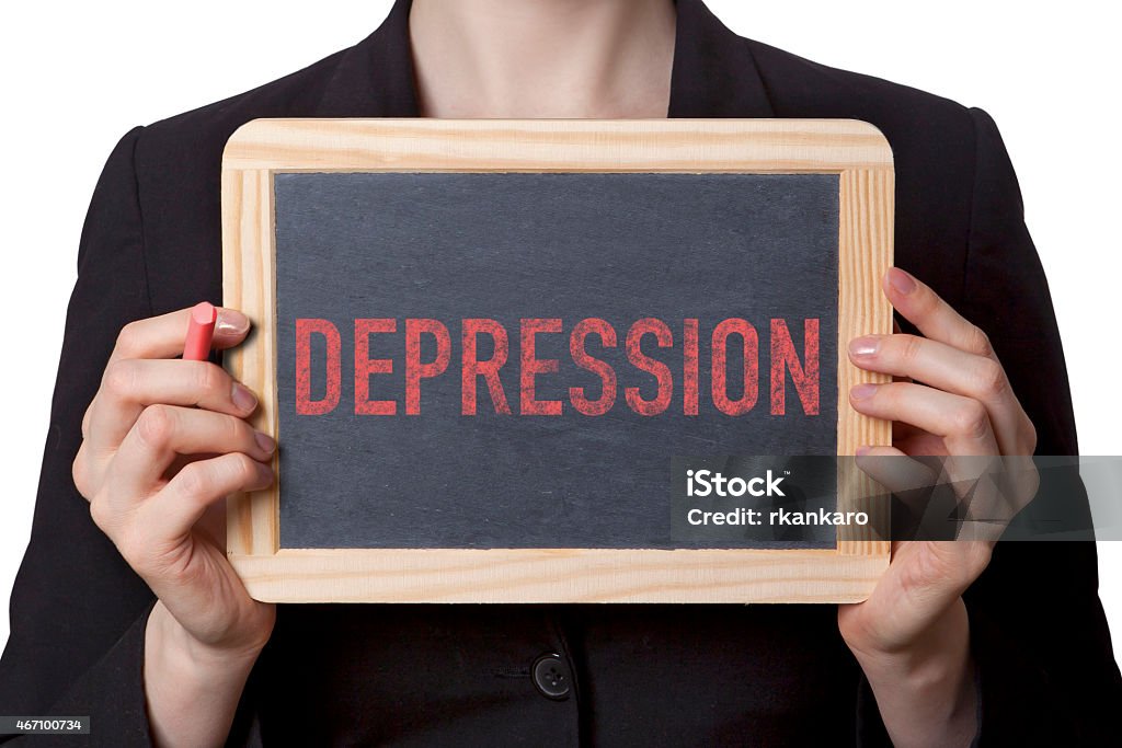 Woman holding a small chalkboard with depression written Woman holding black board with red depression text. White backround. Sick Leave Stock Photo