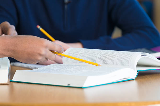 istock Student being tutored in library; reading text books 467100762
