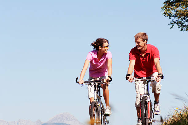 istock Couple riding bikes on meadow 467100946