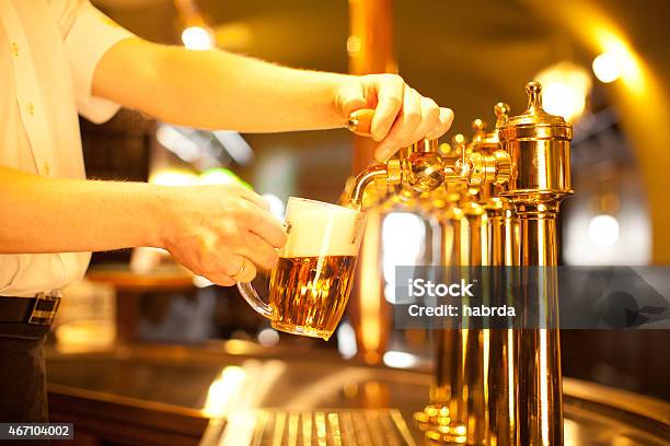 Bartender Filling A Beer Mug From The Tap Stock Photo - Download Image Now - 2015, Bar - Drink Establishment, Bartender