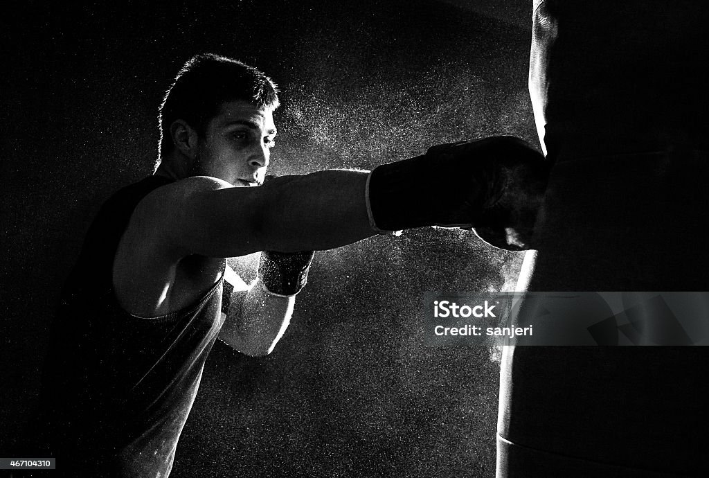 Young man boxing Young man boxing at the punching bag Boxing - Sport Stock Photo