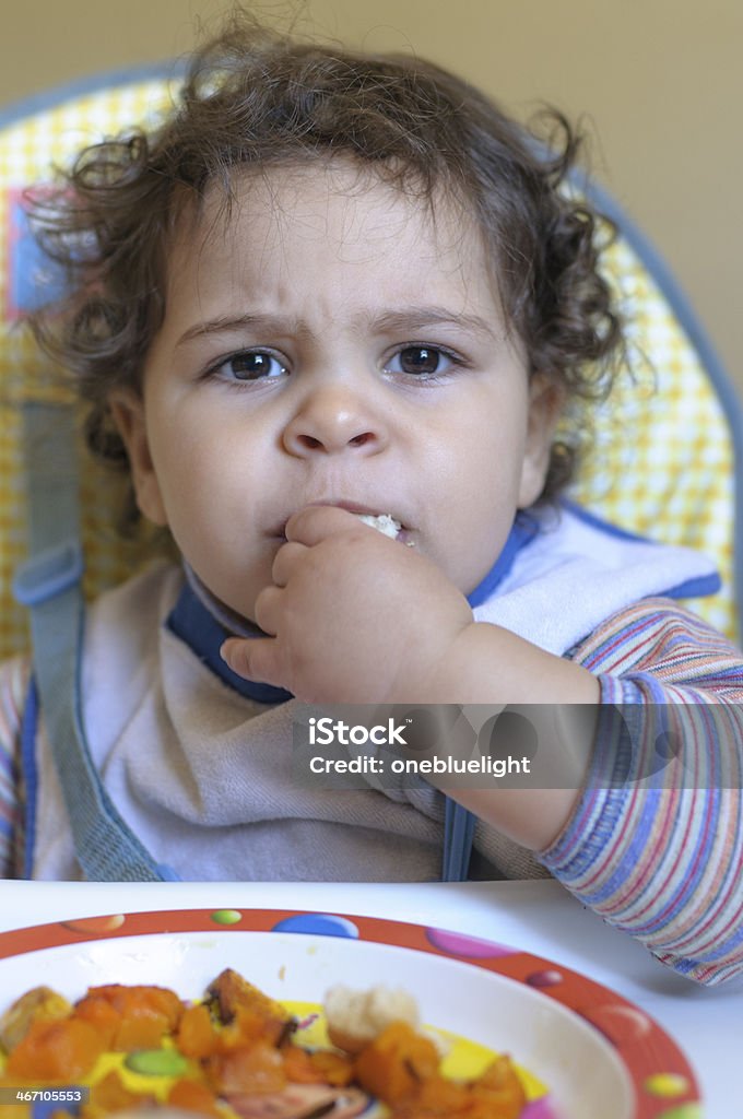 Ragazza bambino mangia da sola, con le dita. - Foto stock royalty-free di 18-23 mesi