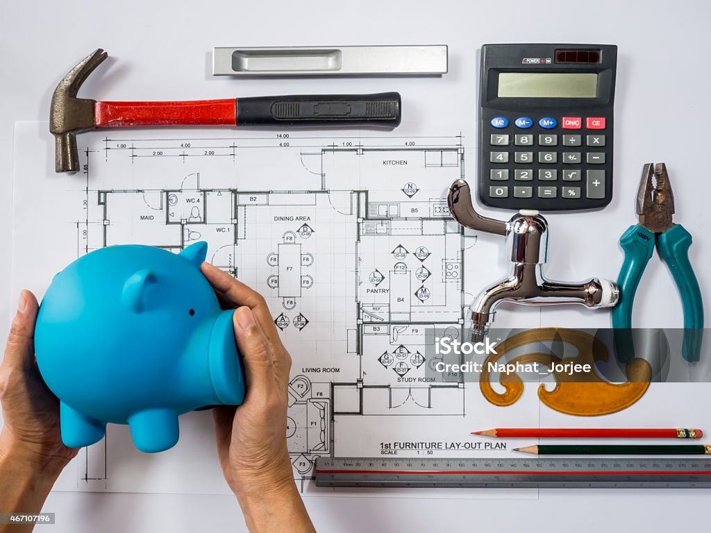 Visual representation of the steps towards home remodeling Hands holding piggy bank over architecture  drawing, planning for  home remodel saving concept Budget Stock Photo
