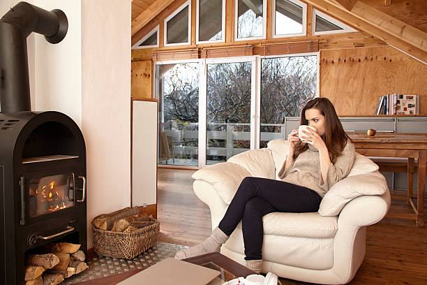 istock Young woman at home in chair drinking tea 467107232