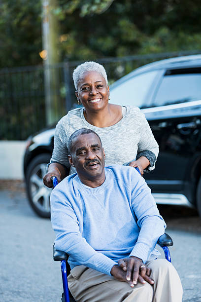 Disabled senior man in wheelchair with his devoted wife