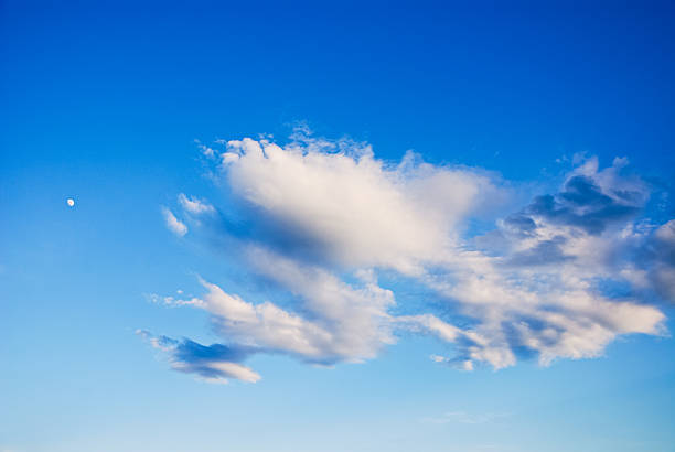 cloud formation in cielo azul con forma de luna creciente - begleiter fotografías e imágenes de stock