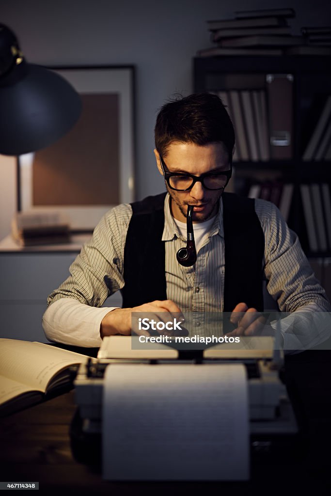 Retro author Retro journalist typing an article on typewriter and smoking a pipe 2015 Stock Photo