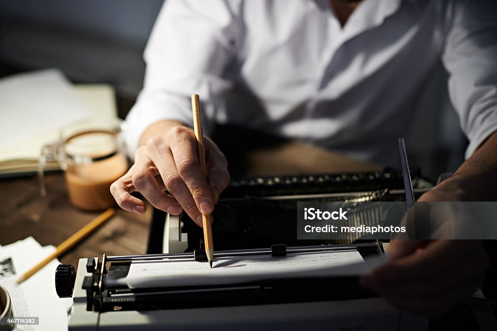 Editing text Journalist typing text on typewriter and correcting it with pencil Typewriter Stock Photo