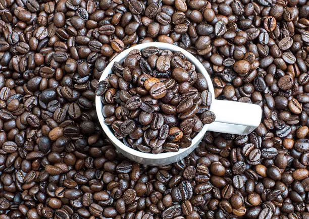 Cup of coffee beans, on the coffee beans background
