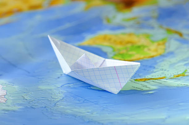 istock Paper boat on a background map of the world 467114720