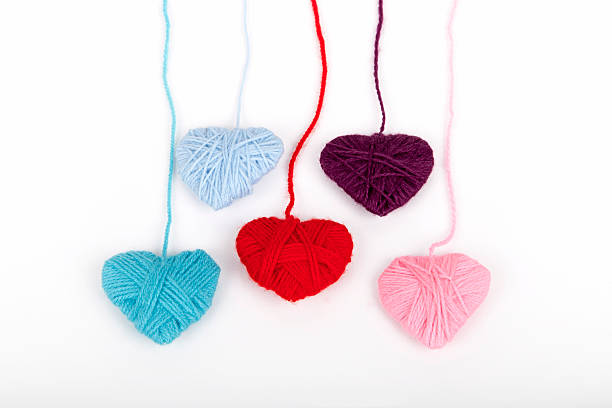 colored woolen yarn and heart colored woolen yarn and heart on a white background knitting textile wool infinity stock pictures, royalty-free photos & images