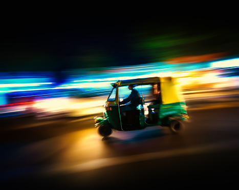 Traditional tuk-tuk from Delhi, India - speeding at night panning/motion blur
