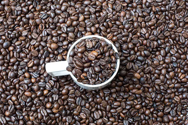 Cup of coffee beans, on the coffee beans background