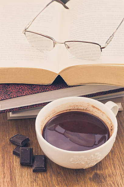 Cup of chocolate on a wooden table with books