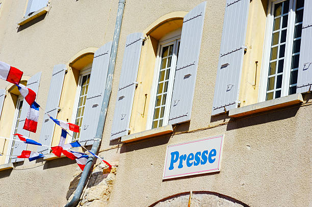 **Generic sign** The French news media sign 'Presse' indicating a newsagent shop. Bunting in the colours of the French tricolour flag is attached to the typical building with shuttered windows