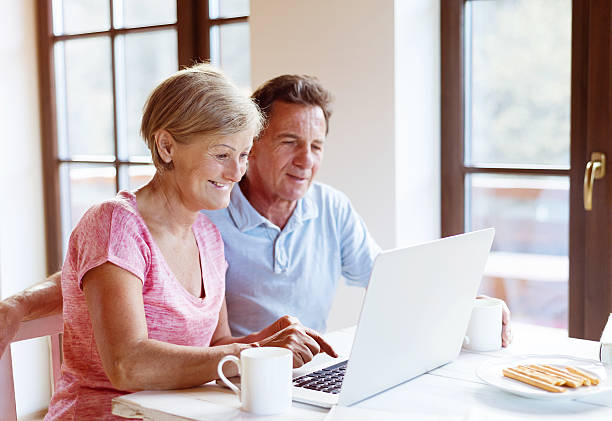 istock An older couple sitting down together and using a laptop 467128000